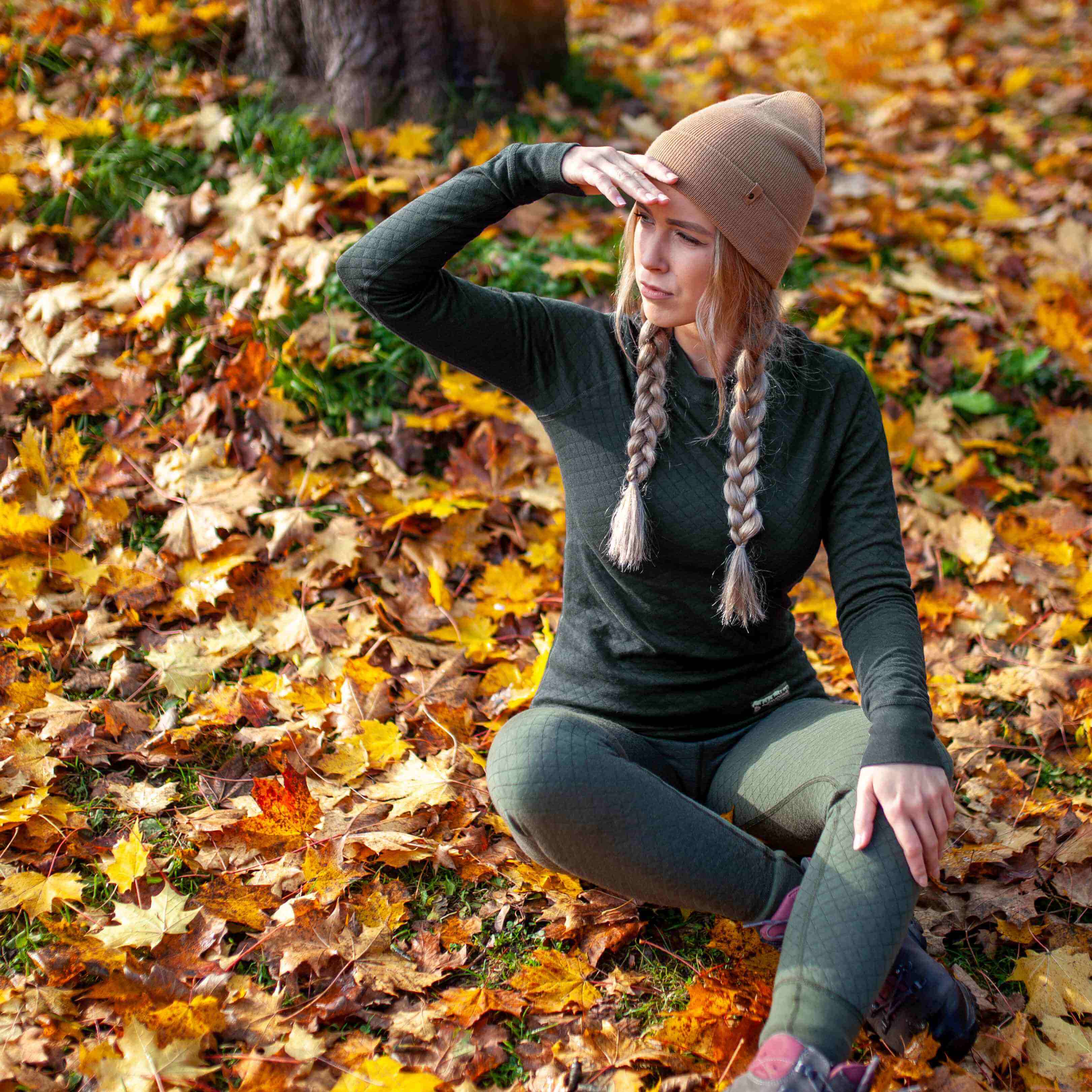 a-woman-in-thermal-clothing-sits-on-a-ground-among-fallen-leaves-in-autumn