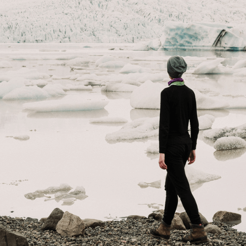 A-woman-with-thermal-shirt-and-pants-walking-near-the-lake-with-icebergs
